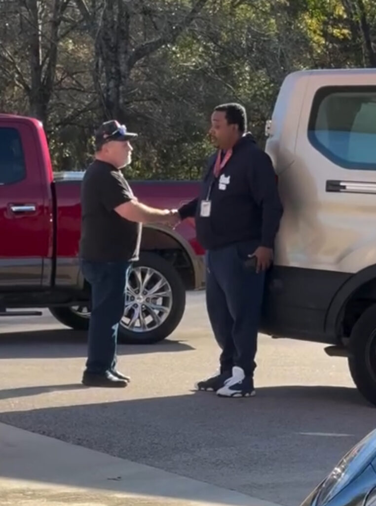 Two men shaking hands after New Bern gas station confrontation