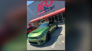 Green Dodge Charger parked in front of APJ auto body shop, Raleigh