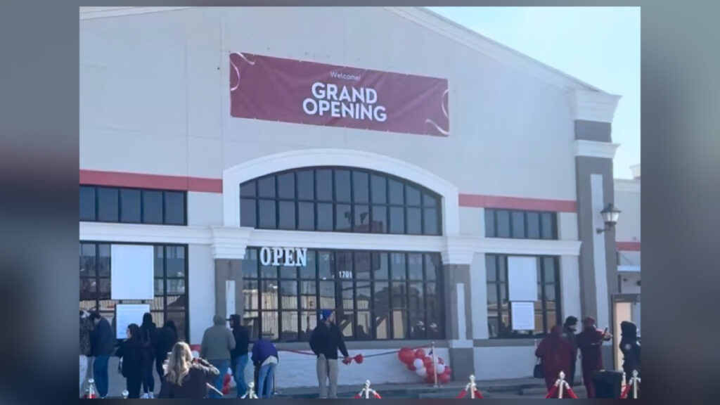The exterior of a grocery store with a large red 'Grand Opening' banner where MrBeast hosted his 250,000 dollar challenge