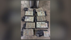 Bundles of seized cash displayed on the floor during a major drug and money laundering investigation