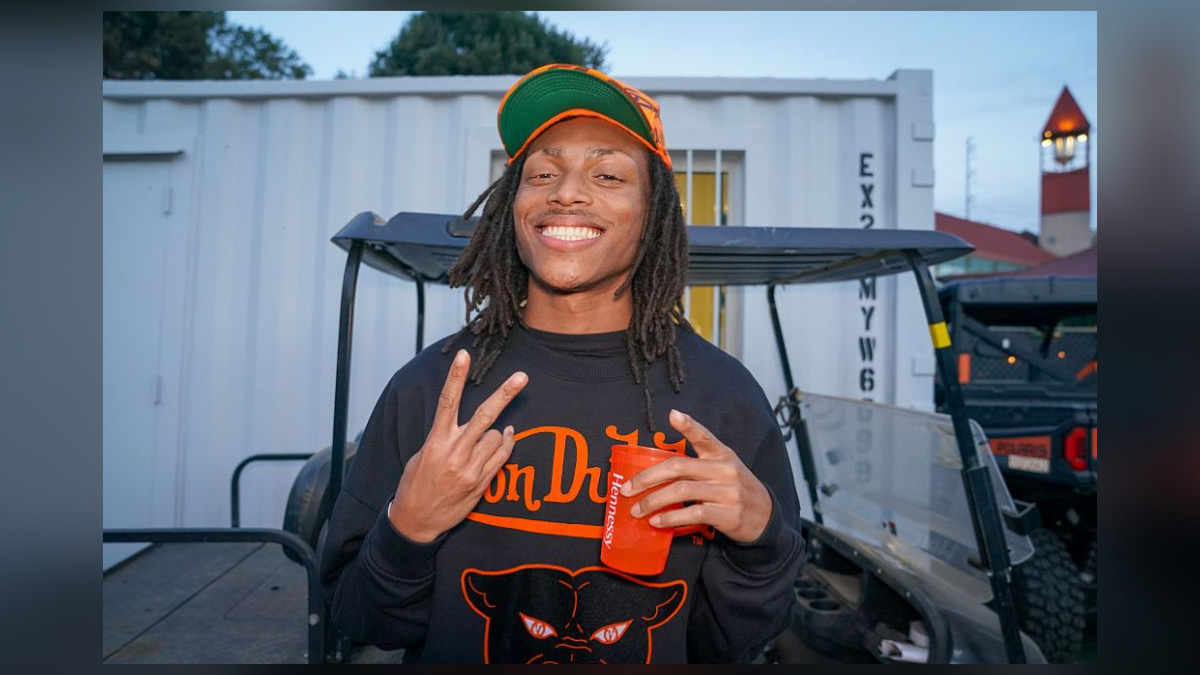 DJ Young Slade talking and gesturing in an interview clip used as the featured image