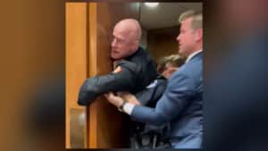 Brian McGinnis Raleigh firefighter protesting inside Senate hearing before being arrested by Capitol Police during Iran war protest