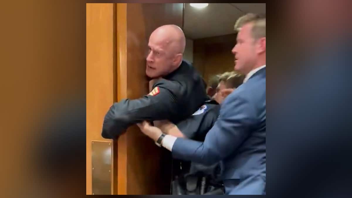 Brian McGinnis Raleigh firefighter protesting inside Senate hearing before being arrested by Capitol Police during Iran war protest