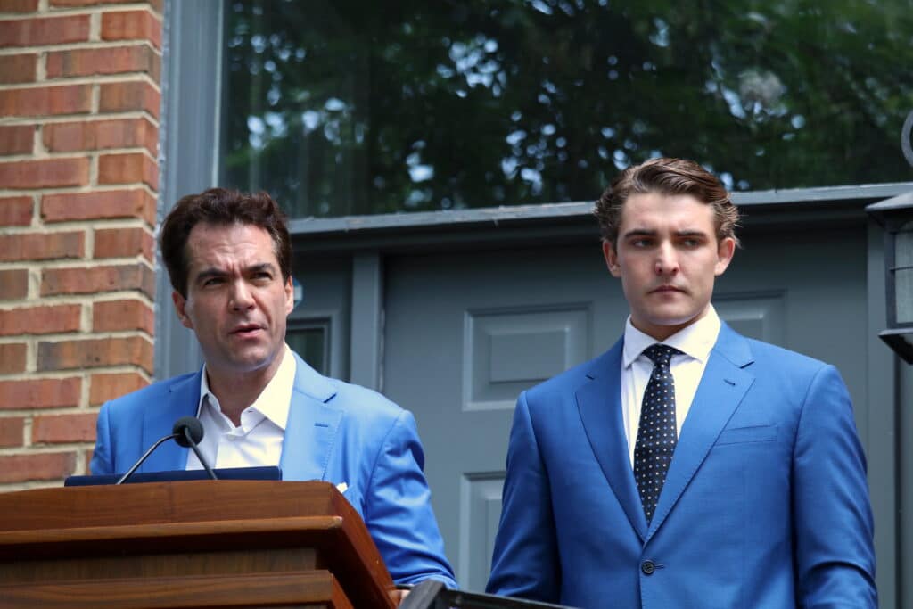 Jacob Wohl and Jack Burkman standing together at podium